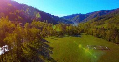 Güneşli yaz sabahında taze dağ nehri ve çayır üzerinde uçuşun ortasında. Aşağıdaki kırsal toprak yol.