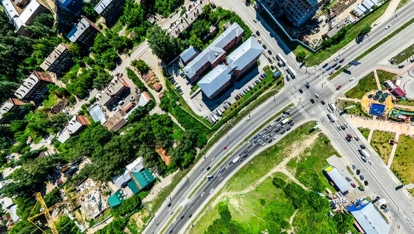 Widok z lotu ptaka na skrzyżowanie dróg i dróg, domy, budynki, parki i parkingi. Słoneczny letni panoramiczny obraz — Zdjęcie stockowe