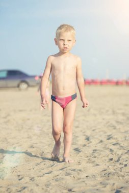 Kumsal deniz kenarında yürürken erkek sevimli bebek. Okyanus kıyısı.