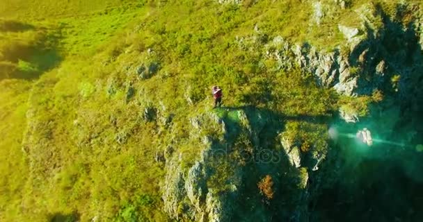 Orbital radiella flygning runt unga vandring man står på toppen av klippan. Tittar bort. — Stockvideo