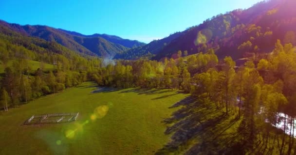 Vuelo en medio del aire sobre el río fresco de la montaña y el prado en la soleada mañana de verano. Camino de tierra rural abajo. — Vídeos de Stock