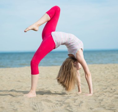 Genç Bayan pratik yoga. Okyanus deniz kıyısına yakın egzersiz.
