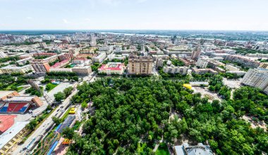 Kesişen yollar, evler, binalar, parklar ve otoparklar olan havacılık şehri manzarası. Güneşli yaz panoramik resmi
