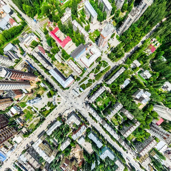 Vista aérea de la ciudad con encrucijadas y caminos, casas, edificios, parques y estacionamientos. Imagen panorámica soleada de verano —  Fotos de Stock