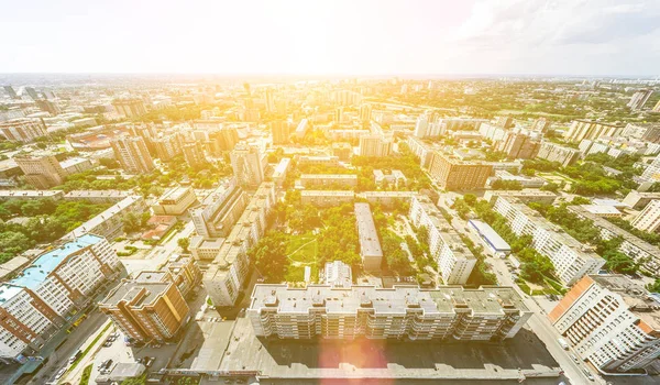 Vista aérea de la ciudad con encrucijadas y caminos, casas, edificios, parques y estacionamientos. Imagen panorámica soleada de verano — Foto de Stock