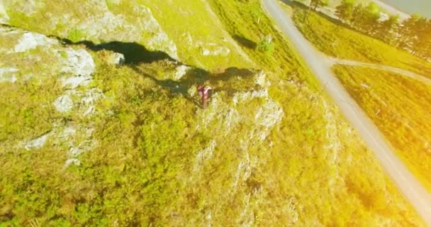 Orbitalradialflug um den jungen Wanderer herum, der oben auf der Klippe steht. Wegschauen. — Stockvideo