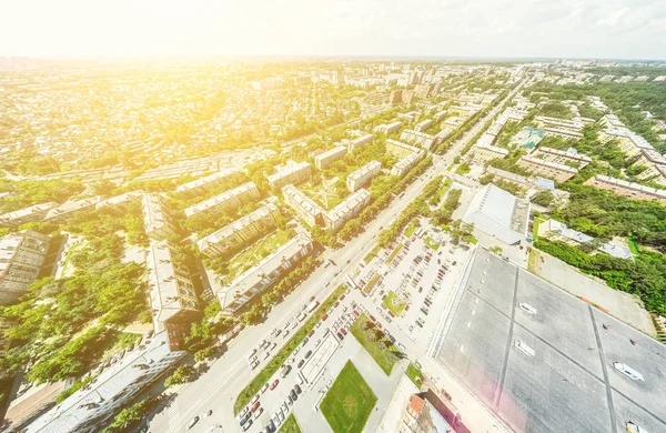 Vista aérea de la ciudad con encrucijadas y caminos, casas, edificios, parques y estacionamientos. Imagen panorámica soleada de verano — Foto de Stock