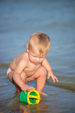 Şirin Bebek kumlu plajı ve deniz suyu oynarken.