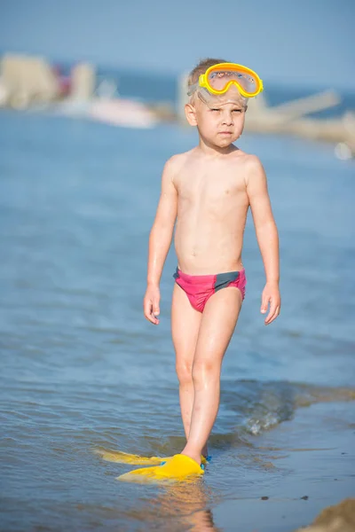 Lindo niño pequeño con máscara y aletas para bucear en la playa tropical de arena . — Foto de Stock