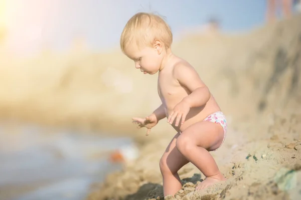 Carino bambino che gioca con i giocattoli sulla spiaggia di sabbia vicino al mare . — Foto Stock