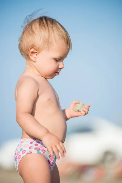 Carino bambino che gioca con i giocattoli sulla spiaggia di sabbia vicino al mare . — Foto Stock