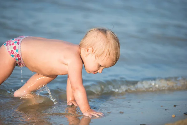 Carino bambino che gioca sulla spiaggia di sabbia e in acqua di mare . — Foto Stock