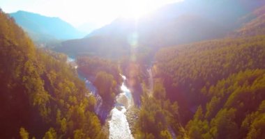 Güneşli yaz sabahında taze dağ nehri ve çayır üzerinde uçuşun ortasında. Aşağıdaki kırsal toprak yol.