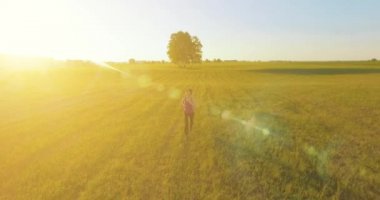 UHD 4k havadan görünümü. Alçak irtifa uçuş kırsal alan, sportif kadının önünde