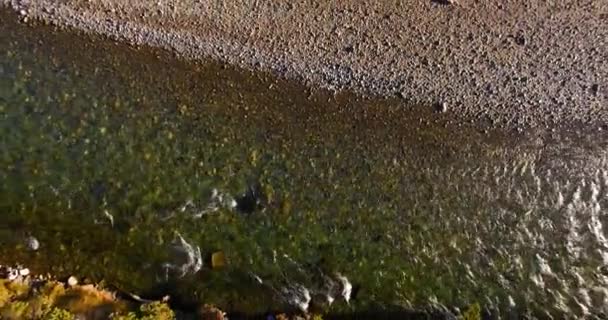 Vol en vol au-dessus d'une rivière de montagne fraîche et propre au matin ensoleillé d'été. Mouvement vertical