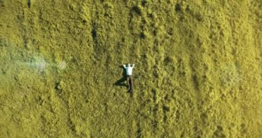 Taze yeşil çayır üzerinde yalan işadamı üzerinde dikey hareket uçuş. Üstten Görünüm üzerinde rahatlatıcı dostum.