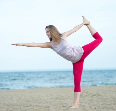 Genç Bayan pratik yoga. Okyanus deniz kıyısına yakın egzersiz.