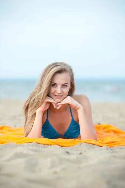 해변에서 일광욕 하는 젊은 여자. 아름 다운 여자에 포즈를 취하는 — 스톡 사진