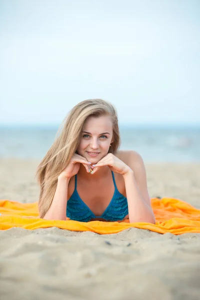 Jonge dame zonnebaden op een strand. Mooie vrouw die zich voordeed op de — Stockfoto