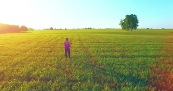 Vol de drone à basse altitude devant une femme sportive sur une route asphaltée parfaite — Video