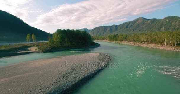 4k UHD aerial view. Low flight over fresh cold mountain river at sunny summer morning. Green trees and sun rays on horisont — Stock Video