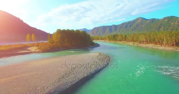 4k UHD vista aerea. Basso volo sul fresco fiume di montagna freddo al soleggiato mattino d'estate. Alberi verdi e raggi di sole su horisont — Video Stock