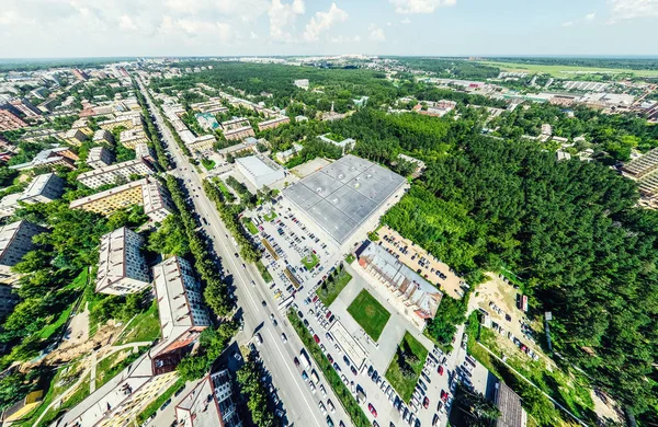 Uitzicht op de stad vanuit de lucht met kruispunten en wegen, huizen, gebouwen, parken en parkeerplaatsen. Zonnige zomer panoramisch beeld — Stockfoto