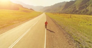 Mükemmel asfalt yol, sportif adamın arkasında alçak irtifa uçuş