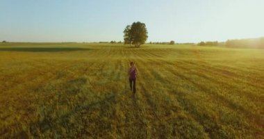 UHD 4k havadan görünümü. Alçak irtifa uçuş kırsal alan, sportif kadının önünde