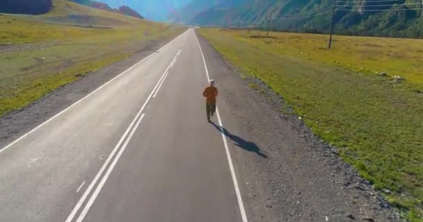 Låghöjdsflygning framför sportig man på perfekt asfalterad väg — Stockvideo