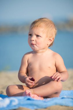 Şirin Bebek denize yakın kum plajındaki oyuncaklar ile oynama.