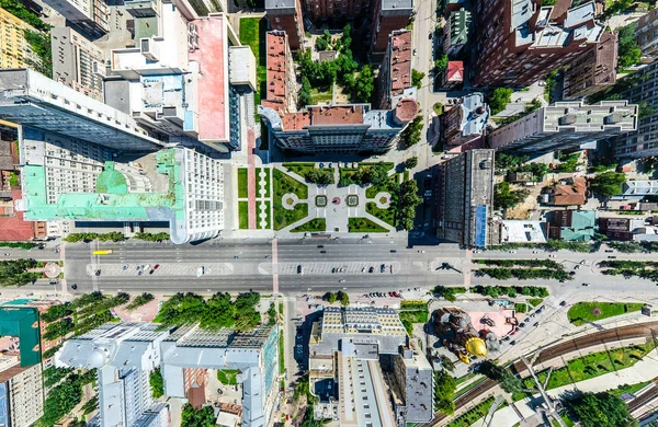 Vista aérea de la ciudad con encrucijadas y caminos, casas, edificios, parques y estacionamientos. Imagen panorámica soleada de verano —  Fotos de Stock