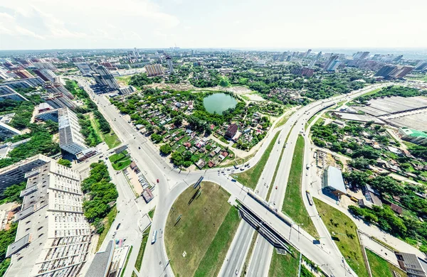 Vista aérea de la ciudad con encrucijadas y caminos, casas, edificios, parques y estacionamientos. Imagen panorámica soleada de verano —  Fotos de Stock