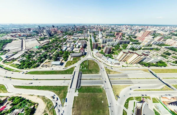 Vista aérea de la ciudad con encrucijadas y caminos, casas, edificios, parques y estacionamientos. Imagen panorámica soleada de verano —  Fotos de Stock