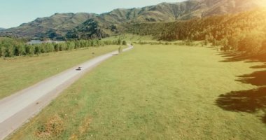 Uçuş otomobil tepeler ve çayır de dolambaçlı bir yol. Kırsal otoyol aşağı.