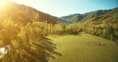 UHD 4k havadan görünümü. Düşük uçuş taze soğuk dağ nehir, çayır ve yola güneşli yaz sabahı.