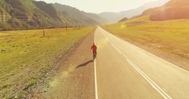 Mükemmel asfalt yol, sportif adamın arkasında alçak irtifa uçuş — Stok video