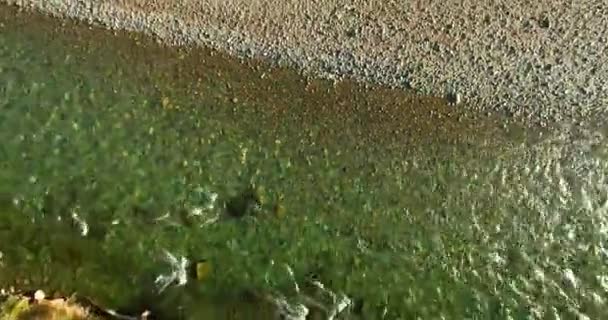 Vol en vol au-dessus d'une rivière de montagne fraîche et propre au matin ensoleillé d'été. Mouvement vertical