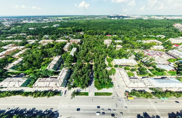 Légi kilátás kereszteződésekkel és utakkal, házak, épületek, parkok és parkolók. Napfényes nyári panoráma kép — Stock Fotó