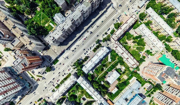 Uitzicht op de stad vanuit de lucht met kruispunten en wegen, huizen, gebouwen, parken en parkeerplaatsen. Zonnige zomer panoramisch beeld — Stockfoto