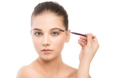 Temiz yüzü ile genç esmer kadın. Kız mükemmel cilt kozmetik fırça uygulamak. Beyaz izole.