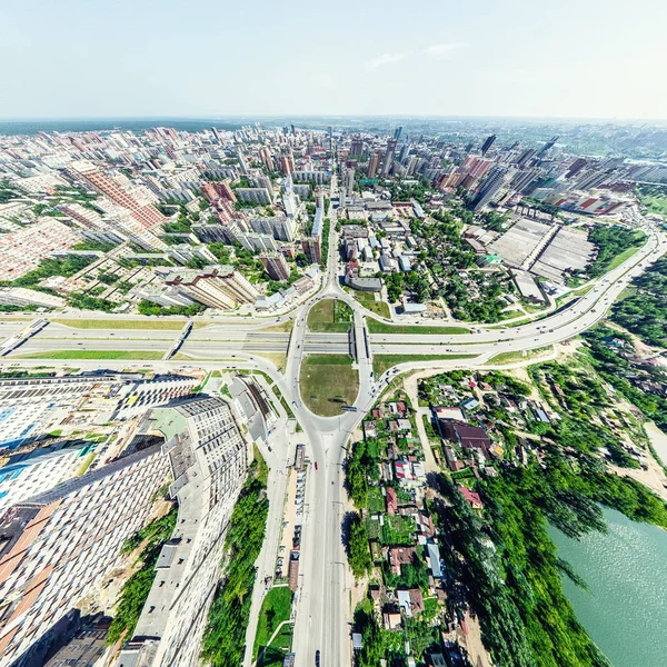 Vista aérea de la ciudad con encrucijadas y caminos, casas, edificios, parques y estacionamientos. Imagen panorámica soleada de verano —  Fotos de Stock