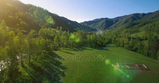 Mid air flygning över färska berg flod och äng på solig sommarmorgon. Landsbygdsvägen nedanför. — Stockvideo