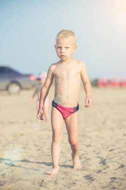 Kumsal deniz kenarında yürürken erkek sevimli bebek. Okyanus kıyısı.