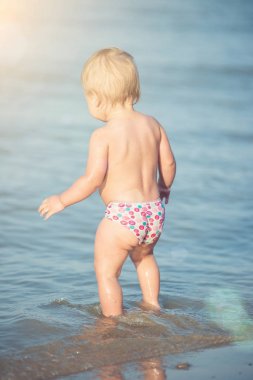 Şirin Bebek kumlu plajı ve deniz suyu oynarken.