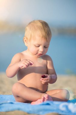Şirin Bebek denize yakın kum plajındaki oyuncaklar ile oynama.