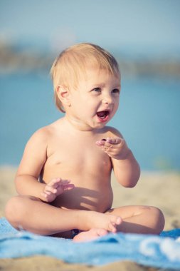 Şirin Bebek denize yakın kum plajındaki oyuncaklar ile oynama.