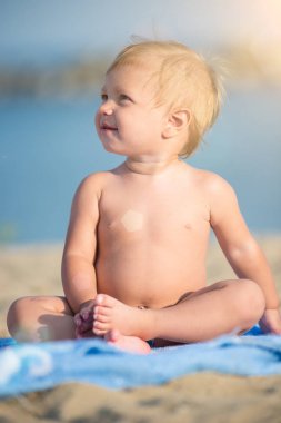 Şirin Bebek denize yakın kum plajındaki oyuncaklar ile oynama.