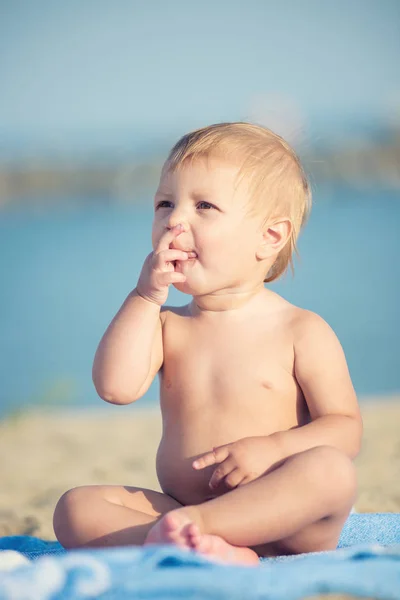 Carino bambino che gioca con i giocattoli sulla spiaggia di sabbia vicino al mare . — Foto Stock