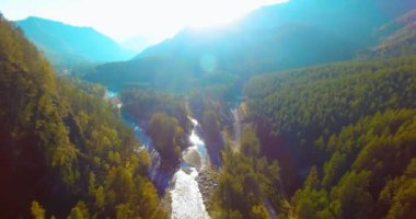 Güneşli yaz sabahında taze dağ nehri ve çayır üzerinde uçuşun ortasında. Aşağıdaki kırsal toprak yol.